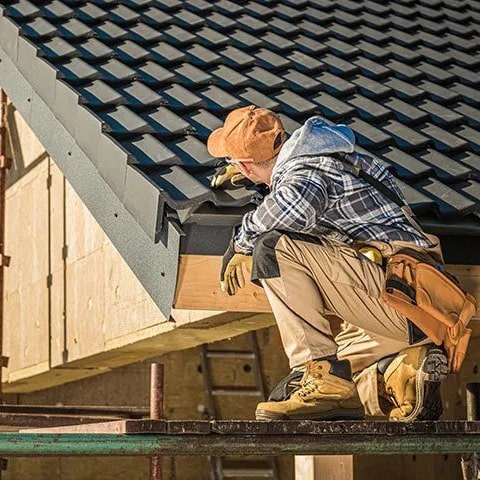 Roofer inspects roof.