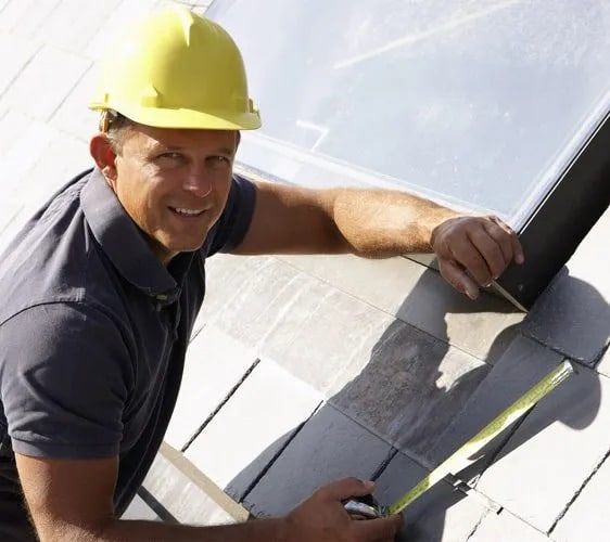 Roofer maintains slate roofing.