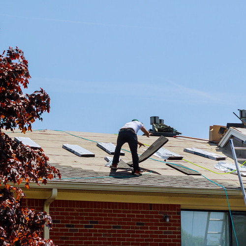 workers repairing a damaged roof