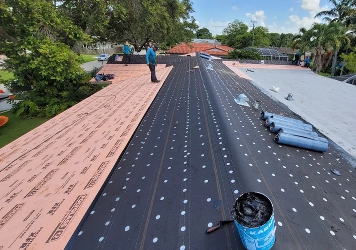 workers installing a shingle roof