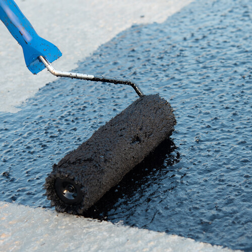 a coating being applied to a flat roof