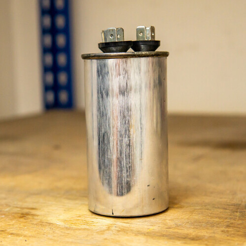 Air conditioner outdoor unit capacitor motor on a wooden shelve.