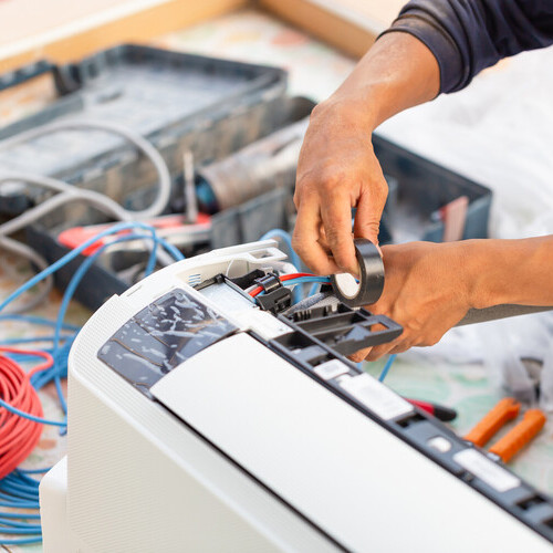 Technician man installing an air conditioning in a client house, Electrician mounting the wires into air conditioning unit, Repairman fixing air conditioner unit, Maintenance and repairing concepts
