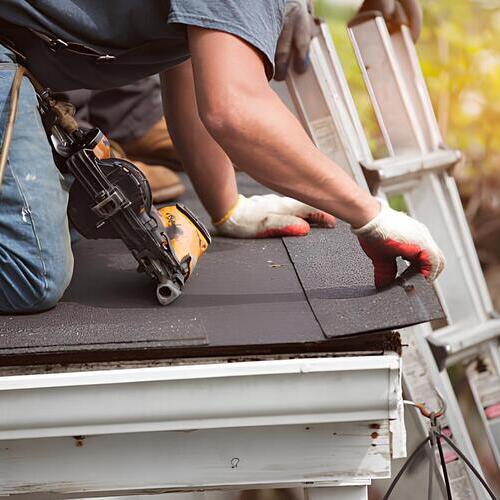 worker repairing a damaged roof