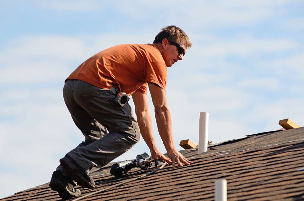 worker on a shingle roof