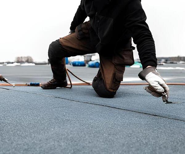 worker applying modified bitumen roofing