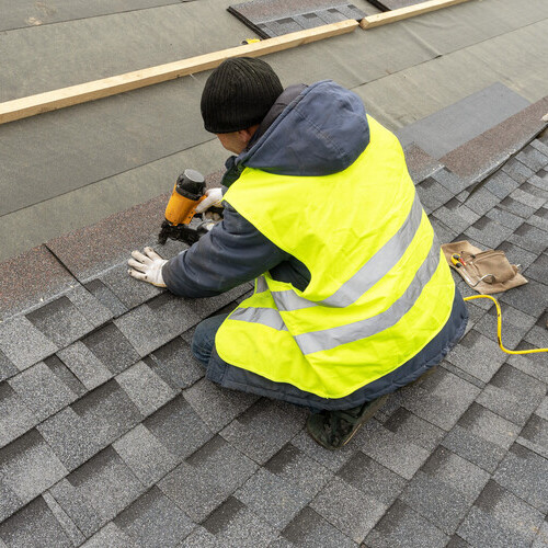 worker installing a shingle roof