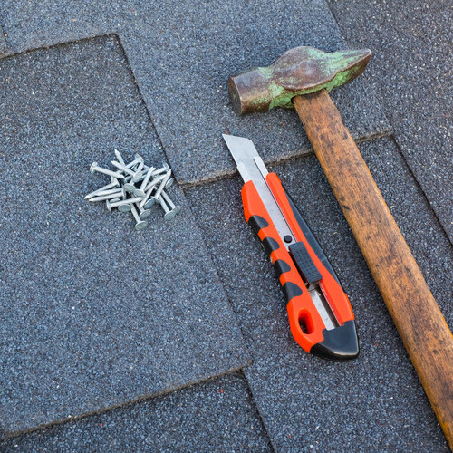 a variety of tools on a shingle roof