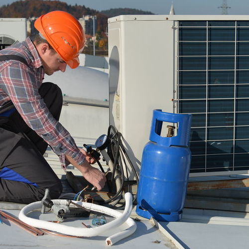 HVAC Technician Works on a Commercial AC.