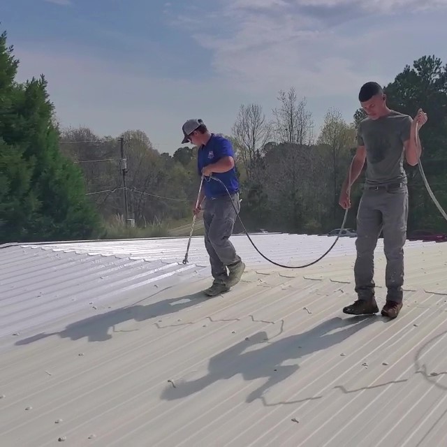 Contractors Spray on a Metal Roof Coating.