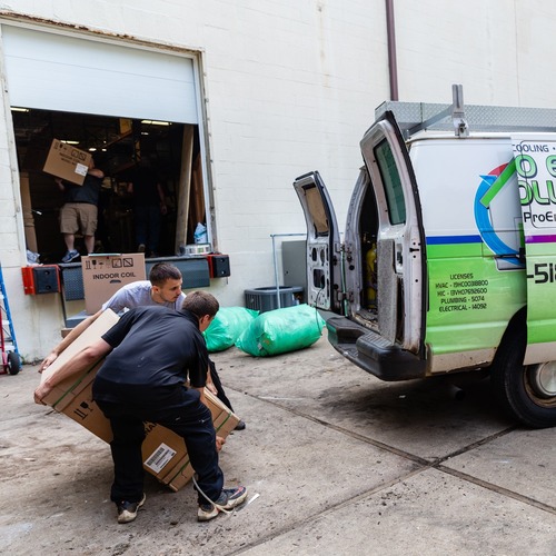 Technicians load a van.