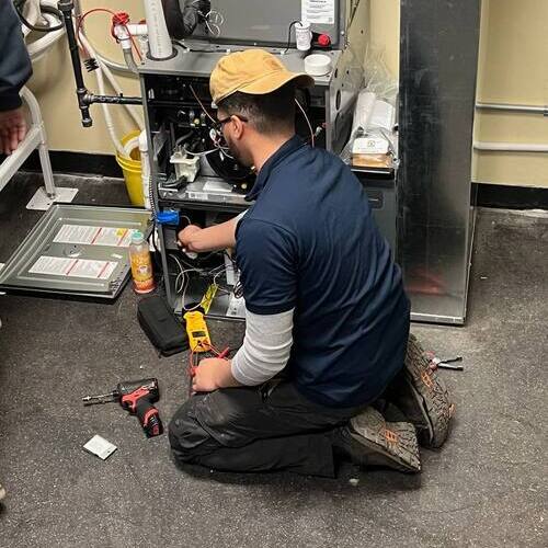 a technician working on a heating unit