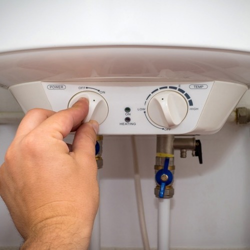 man turning on a water heater