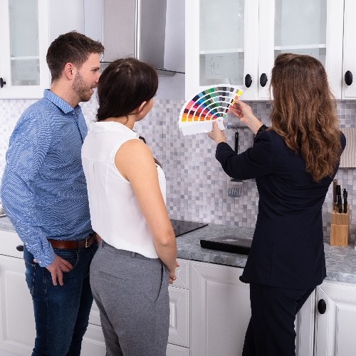 home redesign, expert showing color swaps to a couple in a kitchen